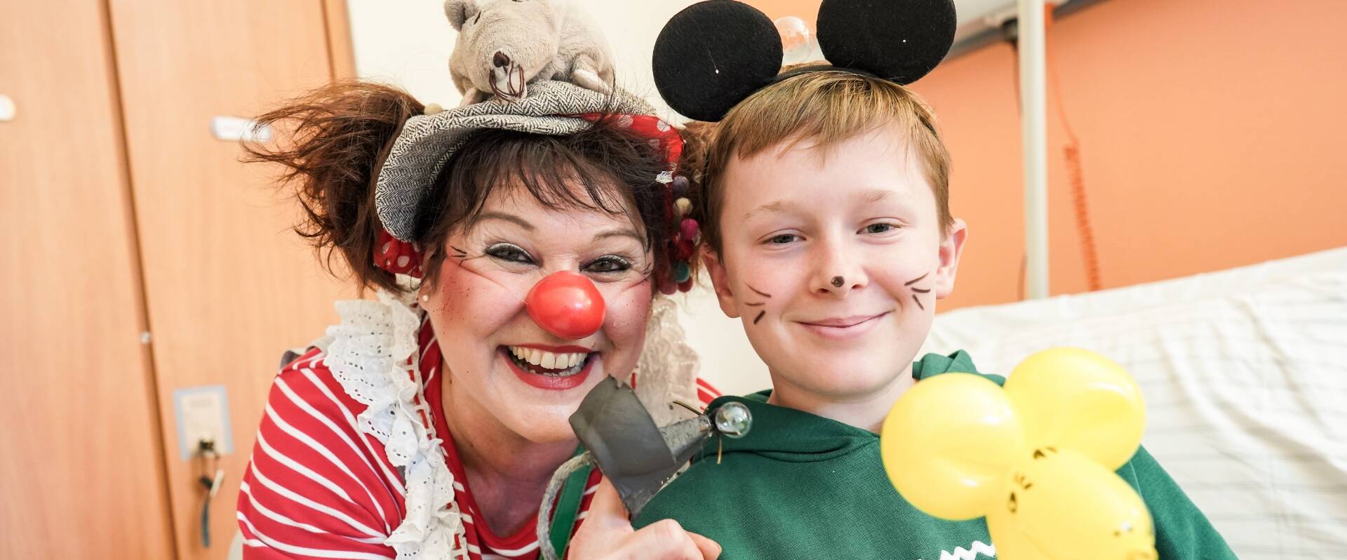 Frau mit Clownsnase und Kind mit Mickey Mouse Ohren